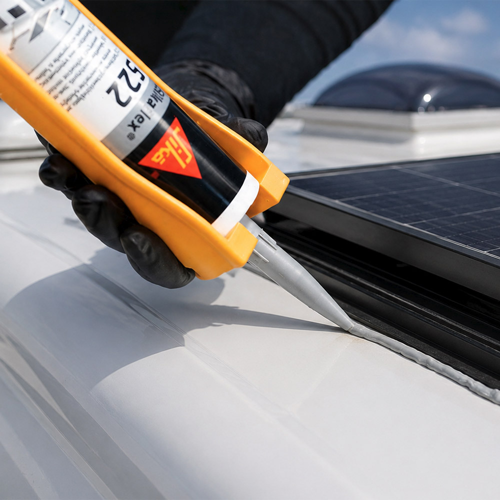 Solarmodul wird mit Hilfe von Sikaflex 522 auf dem Dach eines Wohnmobils verklebt